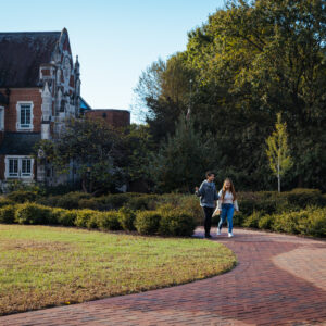 Two students walk down a winding brick path next to Rebekah Scott Hall.