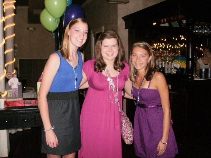 Three girls in dresses in front of balloons