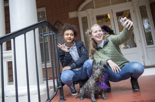 Two students take a selfie with statue of a Scottie dog, Ramona