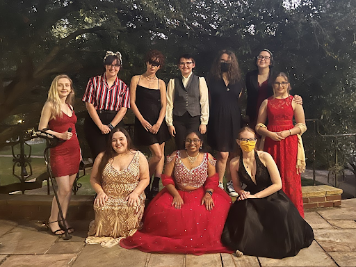 Anjali - smiling widely while wearing a long, red gown - surrounded by her friends before the Black Cat Formal - a favorite tradition here at Agnes Scott!