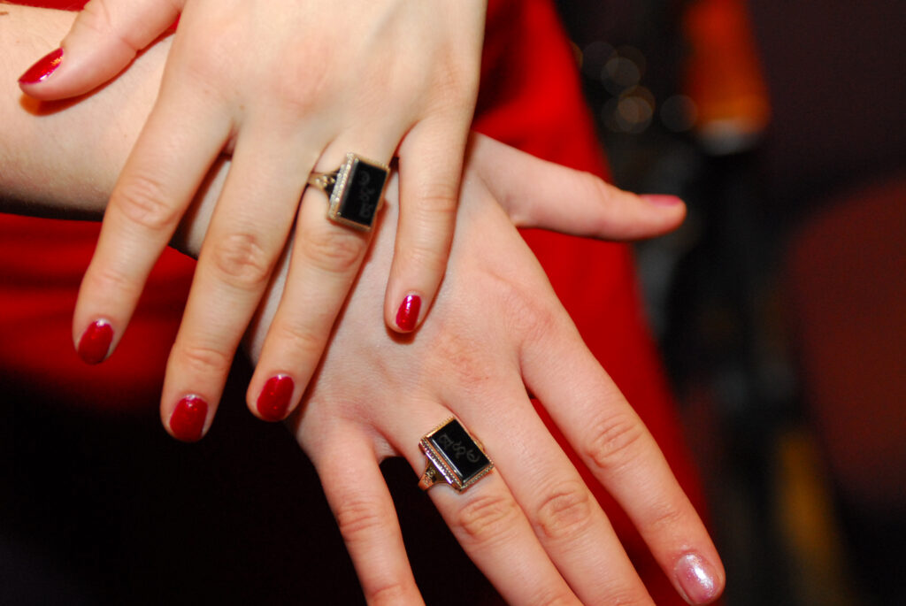 Two Stacked Hands, both with an Agnes Scott ring on their ring finger.