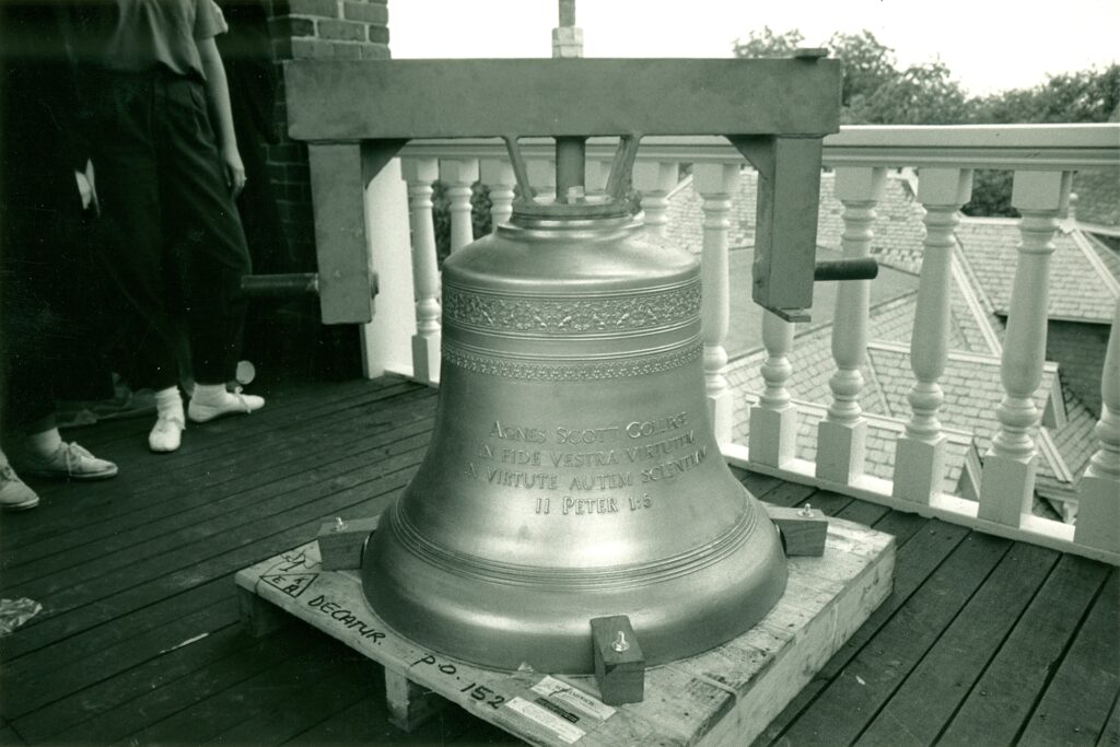 Black and white photograph of a bell with an inscription.