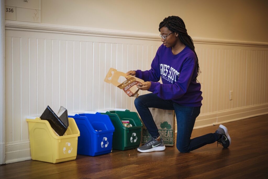 A student considers recycling options in an Agnes Scott residence hall.